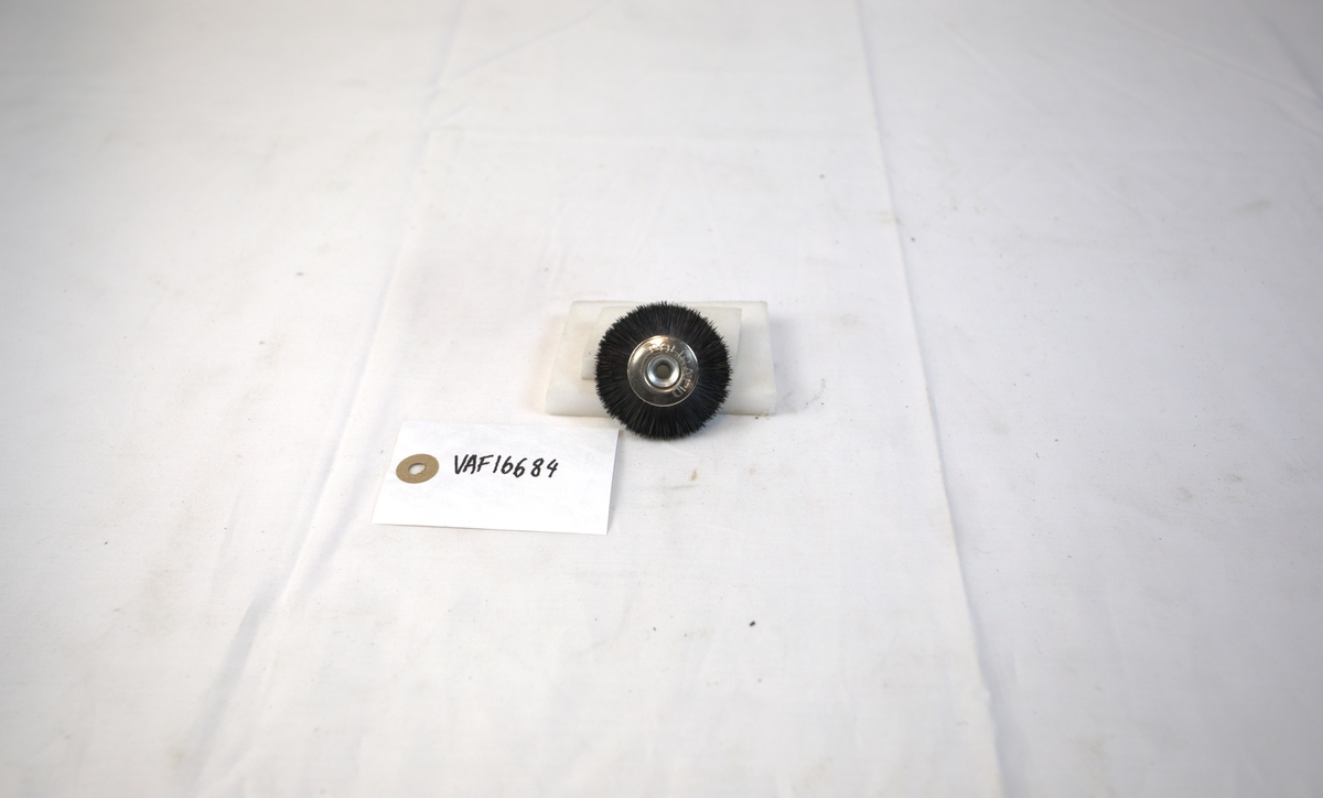 Sirkelformet polerstikkel med børstekant brukt i gullsmedvirksomhet.