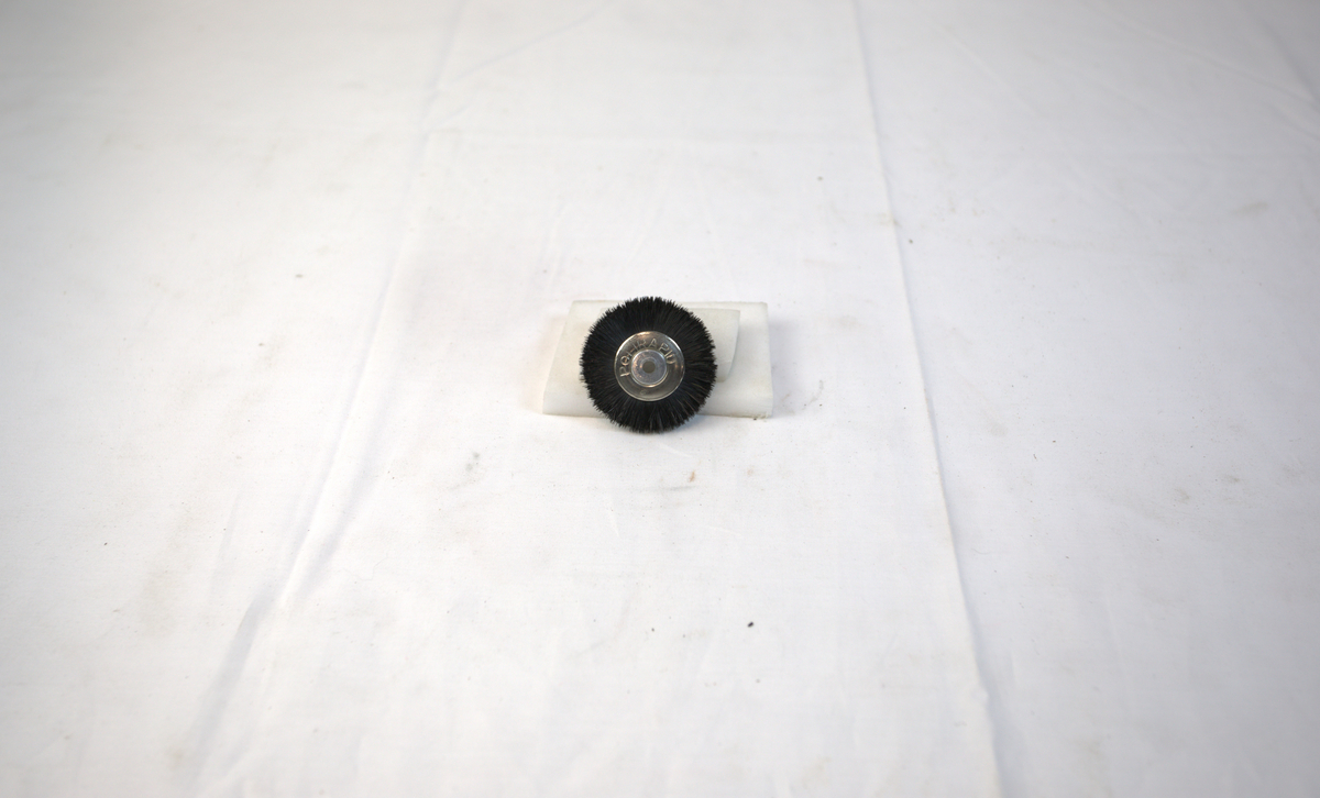 Sirkelformet polerstikkel med børstekant brukt i gullsmedvirksomhet.