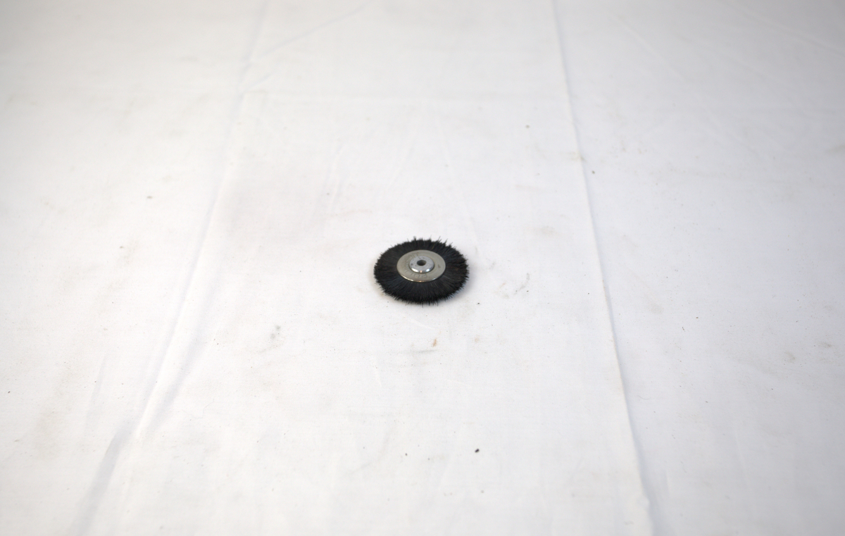 Sirkelformet polerstikkel med børstekant brukt i gullsmedvirksomhet.