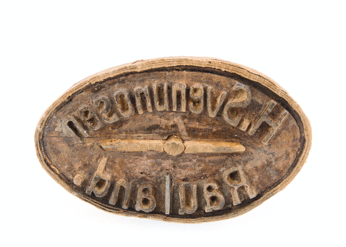 Stempel med teksta "H Svenungsen Rauland" utskore i treverk.

