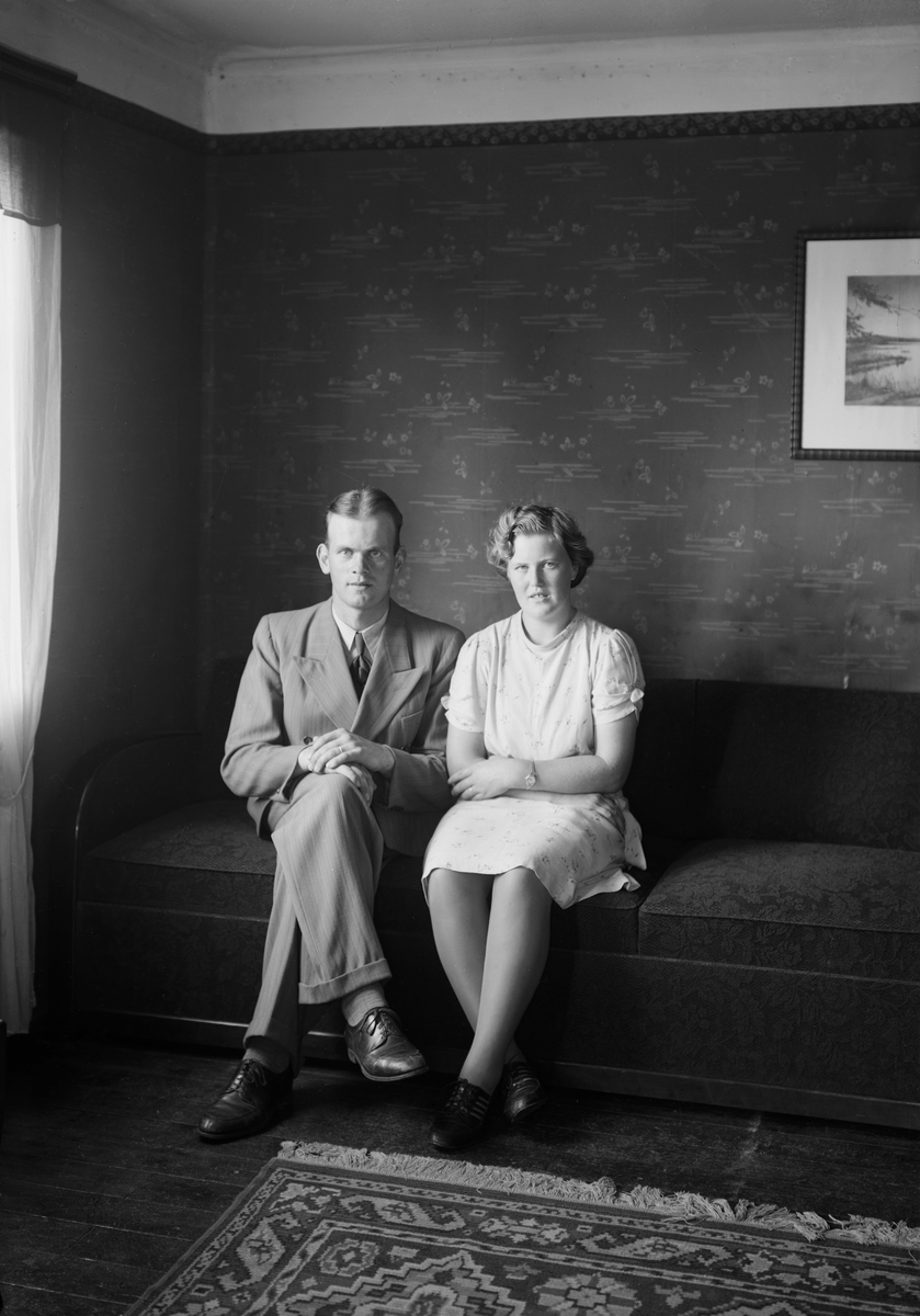 Fästeparet Nils Johansson och Karin Karlsson i finsoffan i vad som kan antas vara hennes föräldrahem i Fundhult, Svinhult. Han brunnsborrare i Götene som funnit sin kärlek i östgötska Ydre. Paret kom att gifta sig 1945 och framleva större delen av sina liv i Lundsbrunn i Götene kommun. I samband med giftemålet antog de efternamnet Ackeby. Foto 1943.