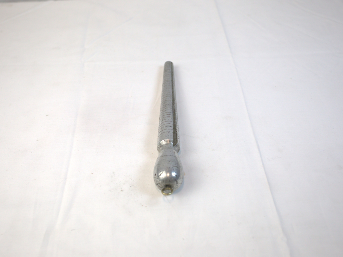 Verktøy til bruk for å lage ringer. Den har striper som går rundt den tilspissede delen. På den ene siden er det også tall i stigende rekkefølge. 