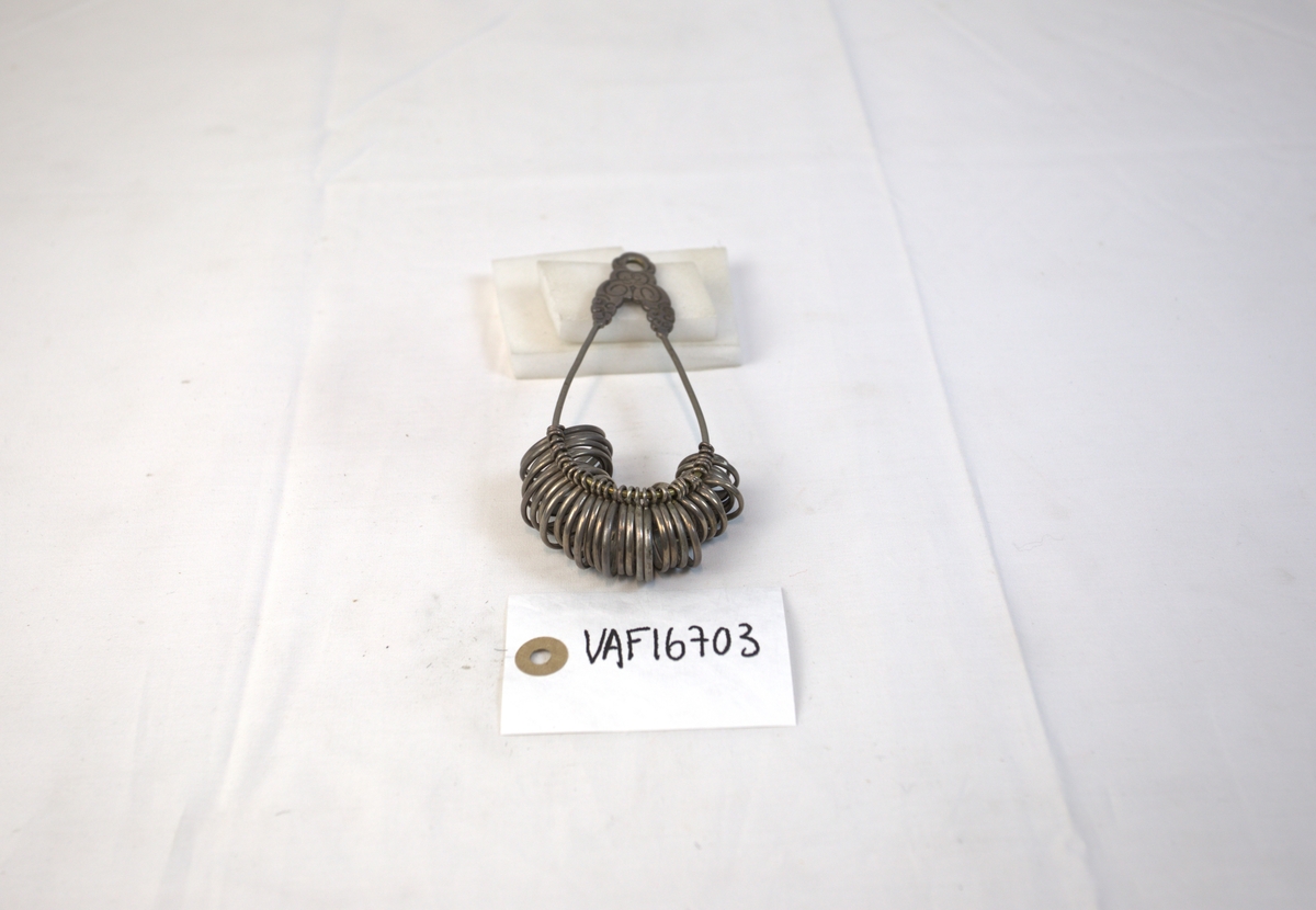 Oppsamling av ringer på oval metallgjenstand. 