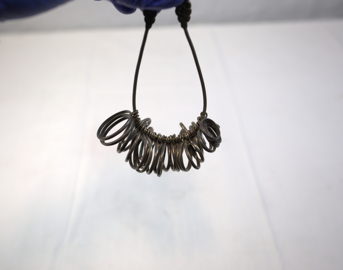 Oppsamling av ringer på oval metallgjenstand. 