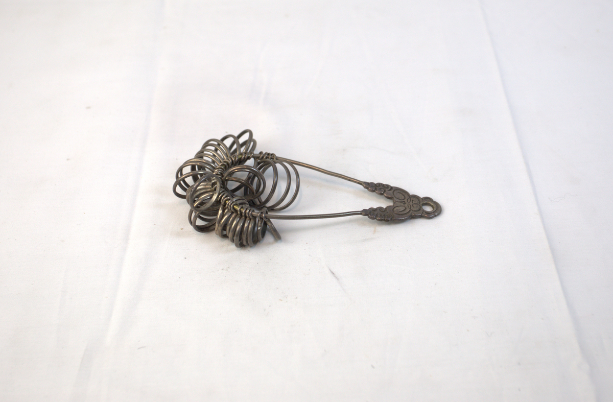 Oppsamling av ringer på oval metallgjenstand. 