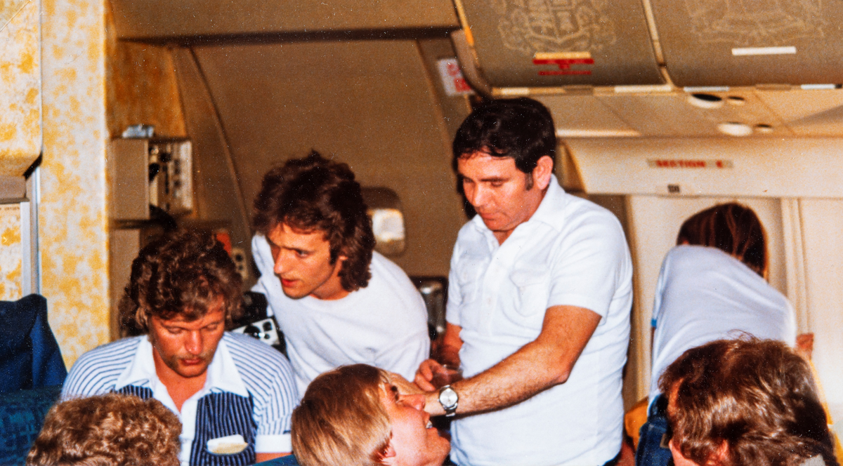 HamKam gutta ombord på flyet mot mot Qatar. Fysioterapaut Vidar Furulund (stripete skjorte) i samtale med Arild Hagen og en ukjent mann. I forkant Stein Erik Kleven.