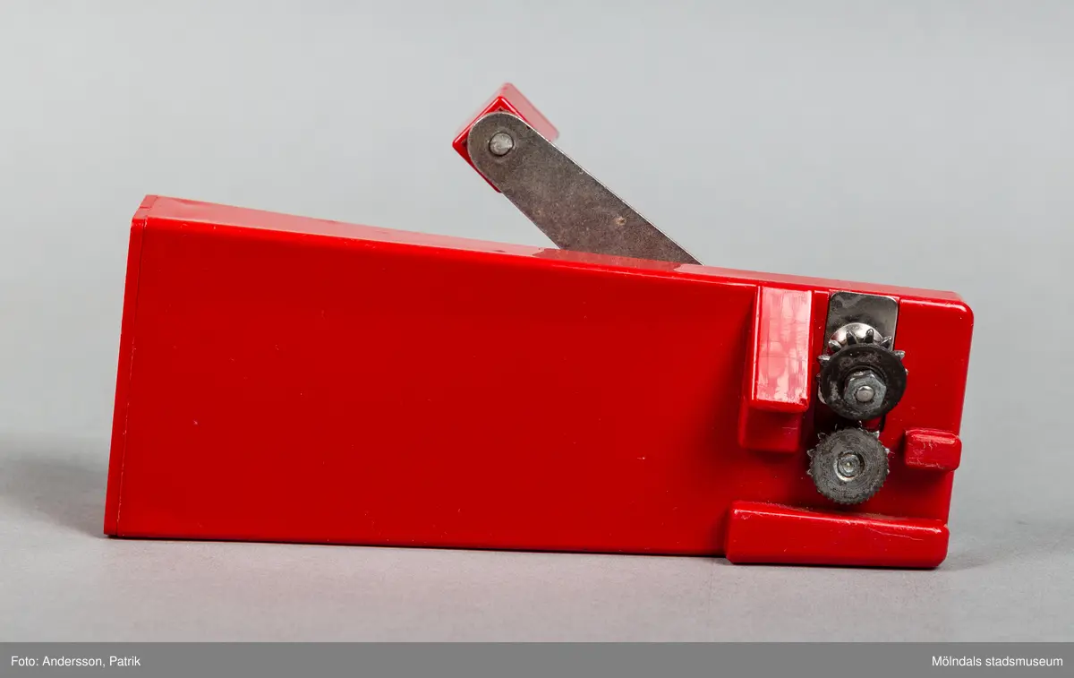 En röd konservöppnare i plast. Den har rektangulär form och en vevarm i metall. Öppnandet sker med hjälp av av två kugghjul som skär sönder locket. Konservöppnaren inkom till Mölndals Stadsmuseum i samband med Matutställningen "Mat i nöd och lust" 2020. Konservöppnaren med namn "Nya Clara" var designad av Sigvard bernadottte 1966 i Företaget "NilsJohan".
Konservöppnaren var väldigt vanlig i svenska hushåll under 1970-talet. Den såldes i 415000 exemplar i Sverige.