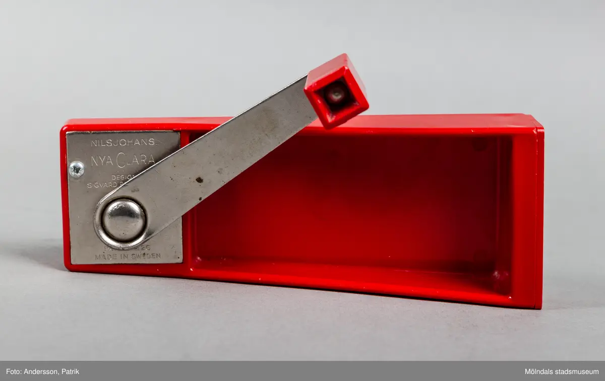 En röd konservöppnare i plast. Den har rektangulär form och en vevarm i metall. Öppnandet sker med hjälp av av två kugghjul som skär sönder locket. Konservöppnaren inkom till Mölndals Stadsmuseum i samband med Matutställningen "Mat i nöd och lust" 2020. Konservöppnaren med namn "Nya Clara" var designad av Sigvard bernadottte 1966 i Företaget "NilsJohan".
Konservöppnaren var väldigt vanlig i svenska hushåll under 1970-talet. Den såldes i 415000 exemplar i Sverige.