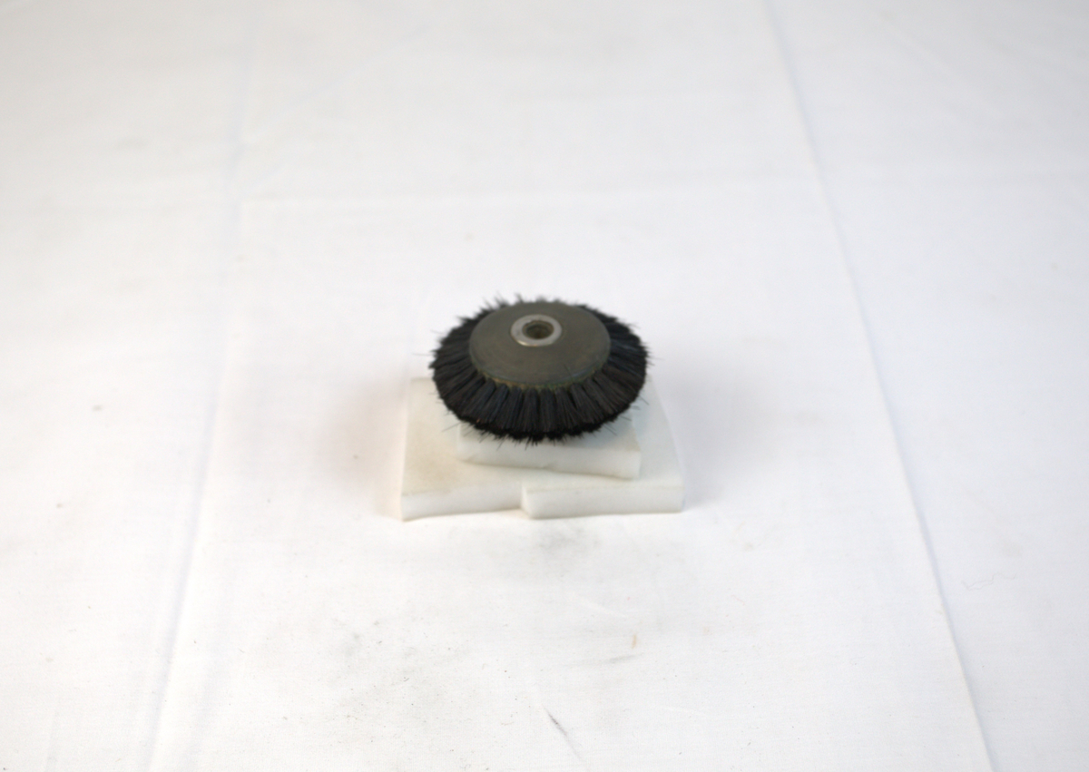 Polerstikkel brukt i gullsmedvirksomhet. Stikkelen har børstekanter.