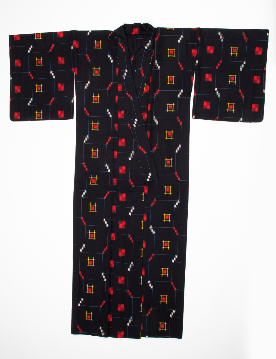 Antrekk som består av en ikatvevd kimono med jakke (haori) i mørkeblå, tynn ull med geometrisk mønster i blått, rødt, hvitt og gult og en underkimono (nagajuban) i rosa og hvit silkekrepp med mønster av traner og bølger. Øvre del av jakken er fôret med hvit, mønstret silkestoff. Tilbehøret består av to knyttebånd i rosa, vevd silke (Ginde-bånd), et reserve-kragestykke (hanori) i silkekrepp til underkimonoen og en elastisk strikk med metallklips til dandering diagonalt over brystet for at plaggene skal sitte pent under. Det følger med et par sokker (tabi) i hvit silke med metallspenner og bomullsfôr og et par sko av geta-typen i svart plast og rødt og hvitt kunstskinn med skinnsåler. To stoffstykker i samme stoff som kimonoen og underkimonoen, antagelig til reparasjon av plaggene.