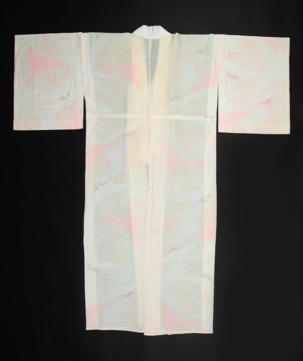 Antrekk som består av en ikatvevd kimono med jakke (haori) i mørkeblå, tynn ull med geometrisk mønster i blått, rødt, hvitt og gult og en underkimono (nagajuban) i rosa og hvit silkekrepp med mønster av traner og bølger. Øvre del av jakken er fôret med hvit, mønstret silkestoff. Tilbehøret består av to knyttebånd i rosa, vevd silke (Ginde-bånd), et reserve-kragestykke (hanori) i silkekrepp til underkimonoen og en elastisk strikk med metallklips til dandering diagonalt over brystet for at plaggene skal sitte pent under. Det følger med et par sokker (tabi) i hvit silke med metallspenner og bomullsfôr og et par sko av geta-typen i svart plast og rødt og hvitt kunstskinn med skinnsåler. To stoffstykker i samme stoff som kimonoen og underkimonoen, antagelig til reparasjon av plaggene.