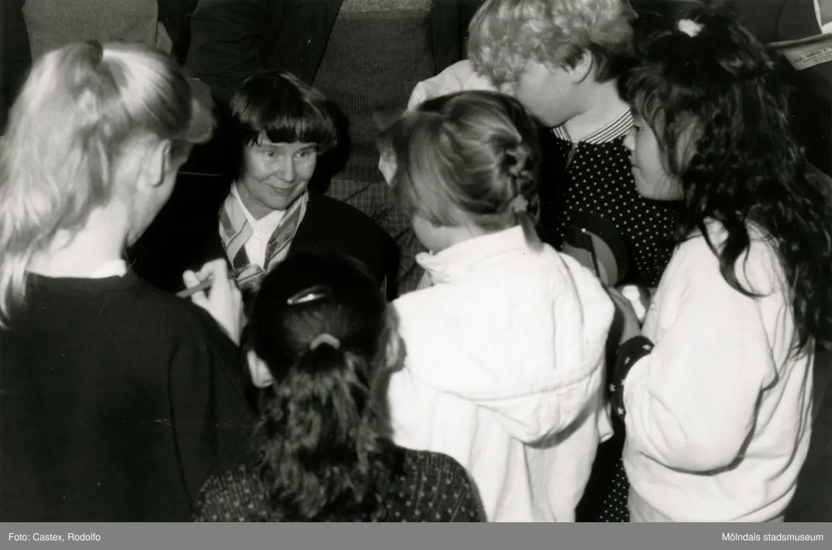 Ordföranden i svenska Unicef-kommittén Lisbeth Palme vid en sammankomst för Unicef i Fässbergsgymnasiets aula i Mölndal, slutet av 1980-talet eller början av 1990-talet. Intill Lisbeth står några barn.