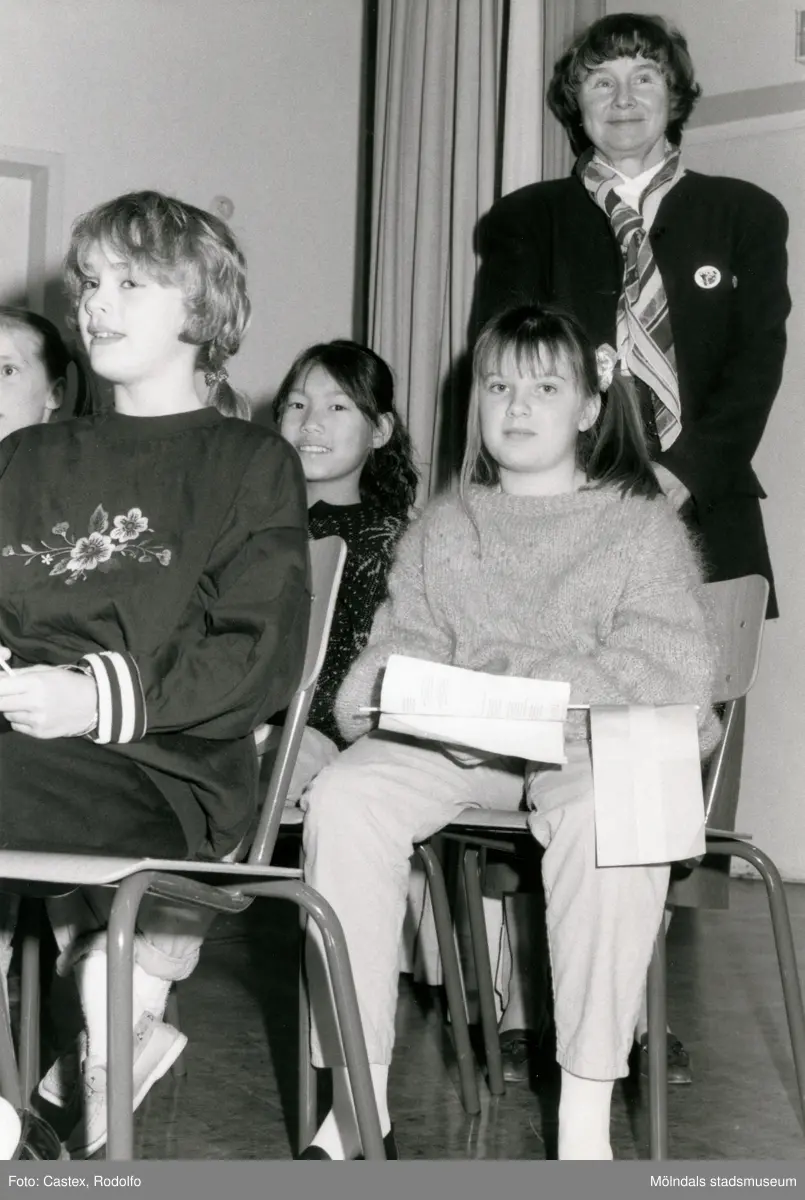 Ordföranden i svenska Unicef-kommittén Lisbeth Palme vid en sammankomst för Unicef i Fässbergsgymnasiets aula i Mölndal, slutet av 1980-talet eller början av 1990-talet. Framför Lisbeth sitter några barn.