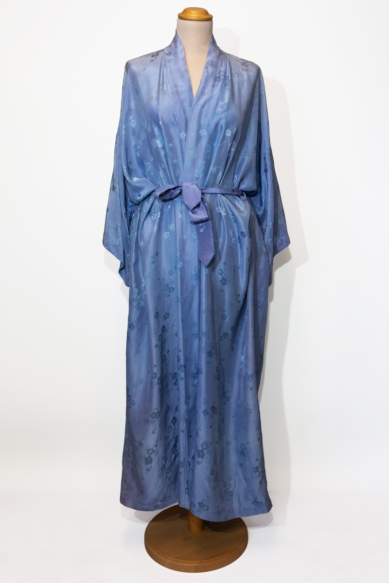 Morgonrock, hellång med tillhörande skärp i ljusblå siden med blommönster i samma färg.