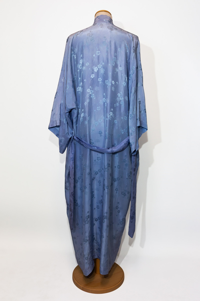 Morgonrock, hellång med tillhörande skärp i ljusblå siden med blommönster i samma färg.