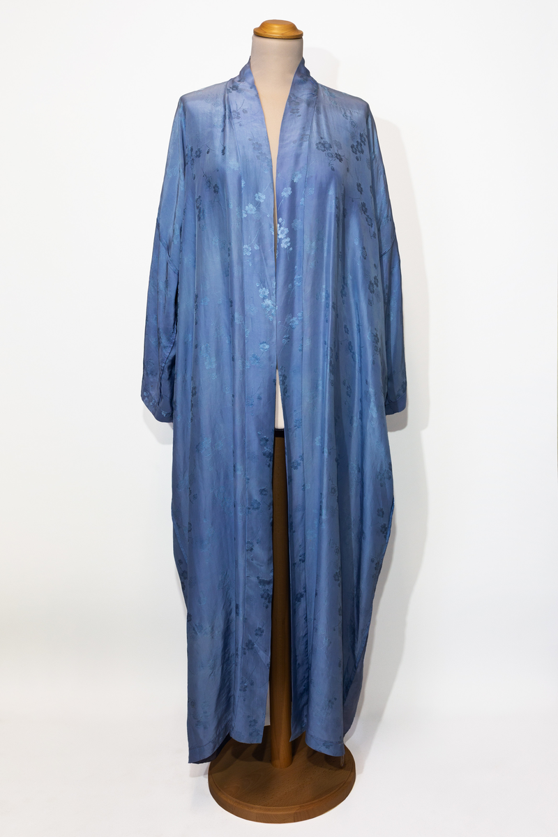 Morgonrock, hellång med tillhörande skärp i ljusblå siden med blommönster i samma färg.