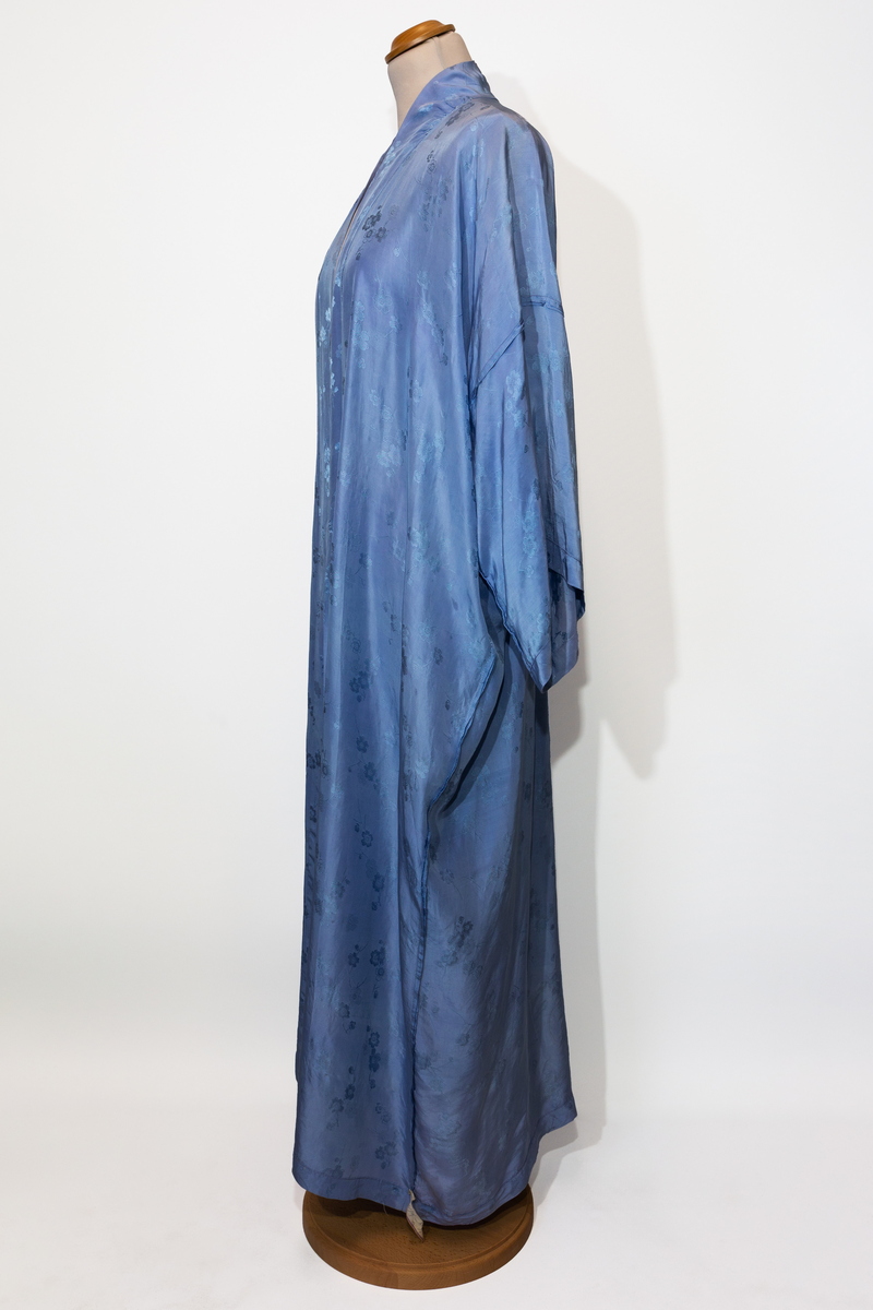 Morgonrock, hellång med tillhörande skärp i ljusblå siden med blommönster i samma färg.