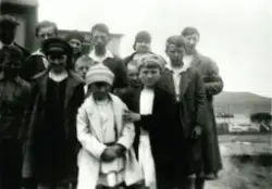 Gruppebilde av flere barn og voksne foran et hus. Antatt Gjesvær. Begynnelsen av 1930-tallet.