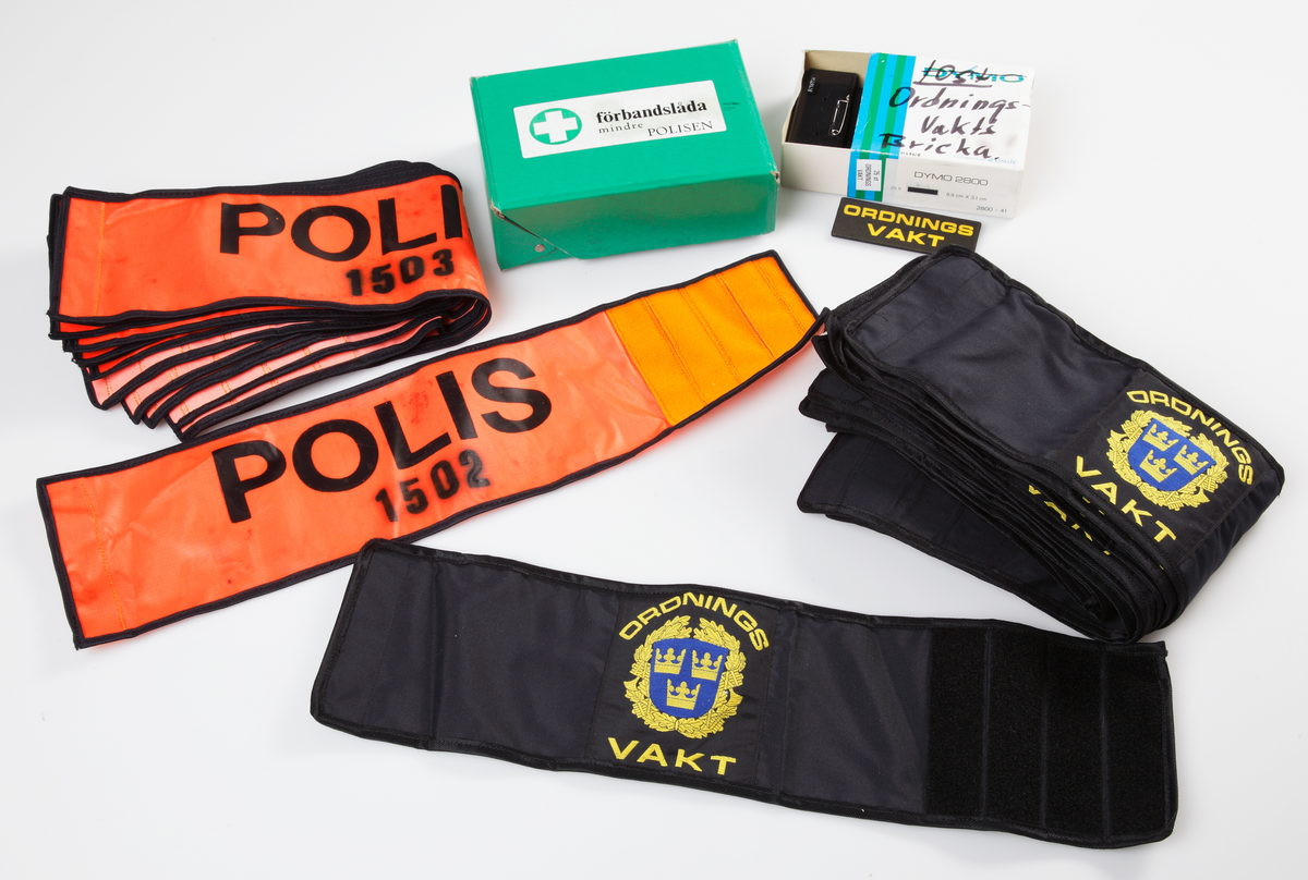 Rektangulär låda i lackad plywood med stålskodda hörn och kanter. Gavlarna försedda med bärhandtag och lås i förzinkad pressad plåt. Lådan kan förvaras liggande, men kan även ställas upp som skåp. Botten och ena gaveln försedda med fotplattor och skenor i plywood resp. trä. Framtill finns två dörrhalvor som kan öppnas. I skåpet finns fem fack som förvaringsutrymmen. Vänsterdörrens insida har en fastskruvad lampa som koplas till ett cigarettuttag. Här finns även tio hållare för pennor. Högerdörren har en innehållsförteckning för skåpet, och vissa adresslistor fästa med häftstift. Lådans utsida märkt på ena dörren "ÄLMHULTS POLISDISTRIKT LEDN. PL. FÄLT", och i botten "AB PLYFA MALMÖ".

Lådan innehåller i översta facket till vänster: en ficklampa märkt Durabcam, fäst med spännmand i lådan, plastlåda innehållande knappnålar, småspik, 14 färgkritor, tavelkritor, tre suddgummin, en Ballografpenna och en blyertspenna.

Översta facket till höger: en skyddshandbok, boken "Grövre våldsbrott", "SamRik del 2A", "Anmälningsrutiner, "telekatalog för polis- och åklagarväsendena, rulle med pappersremsa, förpackningar, plastnålar, Primus gasolvärmare, Primus gasolplatta med tub, RX limflaska, plastlinjal, hålslag märkt Ojop, rulle med etiketter, tejprulle märkt Tesa, morakniv med fodral, gem i magnetburk, två gemaskar, en ask med häftstift märkt Olfa, stämpeldyna märkt Artline, stämpel från Polismyndigheten i Älmhult.

Nedre facket till vänster: Pärm innehållande: Skrivblock, skrivpapper, Ansökan om ordningsvakt, Konceptanmälan, Spaningsuppslag grövre brottmål, Förhör, Förordnande av ordningsvakt, plastfickor.
Pärm innehållande: Inmönstring, listor, adresser, personal.
Pärm innehållande: Aktuellt, fall, åtgärder.

Nedre facket till höger: Pärm innehållande: Personal, Insatsgrupper.
Pärm innehållande: Polisens Räddningstjänst.
Pärm innehållande: Älmhults Polisdistrikt, rulle med pappersremsa.

Bottenhyllan: Kastrull med lock, köttbuljong, snabbkaffe, teförpackning, 30 plasmuggar, ca 15 plastskedar, sex teskedar i stål, förbandslåda med innehåll, 10 ordningsvaktsbrickor, 10 armbindlar i svart för ordningsvakt, 9 armbindlar för Polis, en väst för Polis insatschef, ett sittunderlag ?

Insidan på vänster dörr: En sax, två blyertspennor, en färgkrita, tre tuschpennor, en lampa för cigarettuttag.

Insidan på höger dörr: Skåpets innehållsförteckning och Radio Kronobergs larmlista.
