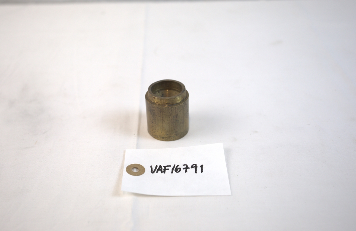 Sirkelformet metallgjenstand med fordypning i toppen. 