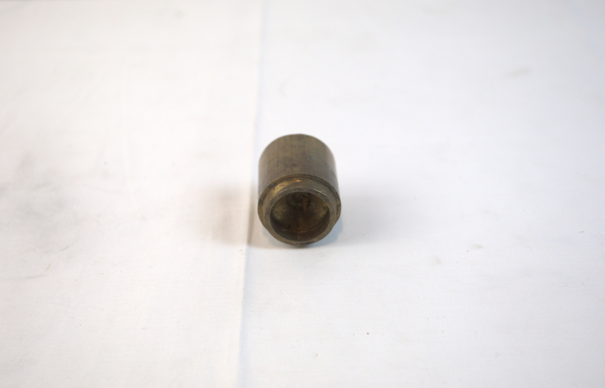 Sirkelformet metallgjenstand med fordypning i toppen. 