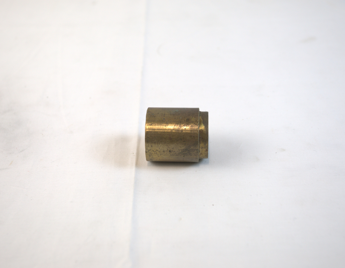 Sirkelformet metallgjenstand med fordypning i toppen. 