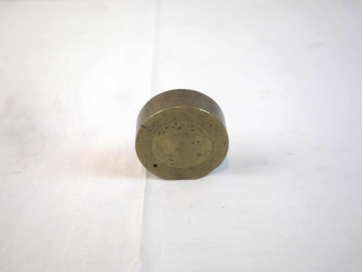 Sirkelformet metallgjenstand med fordypning.