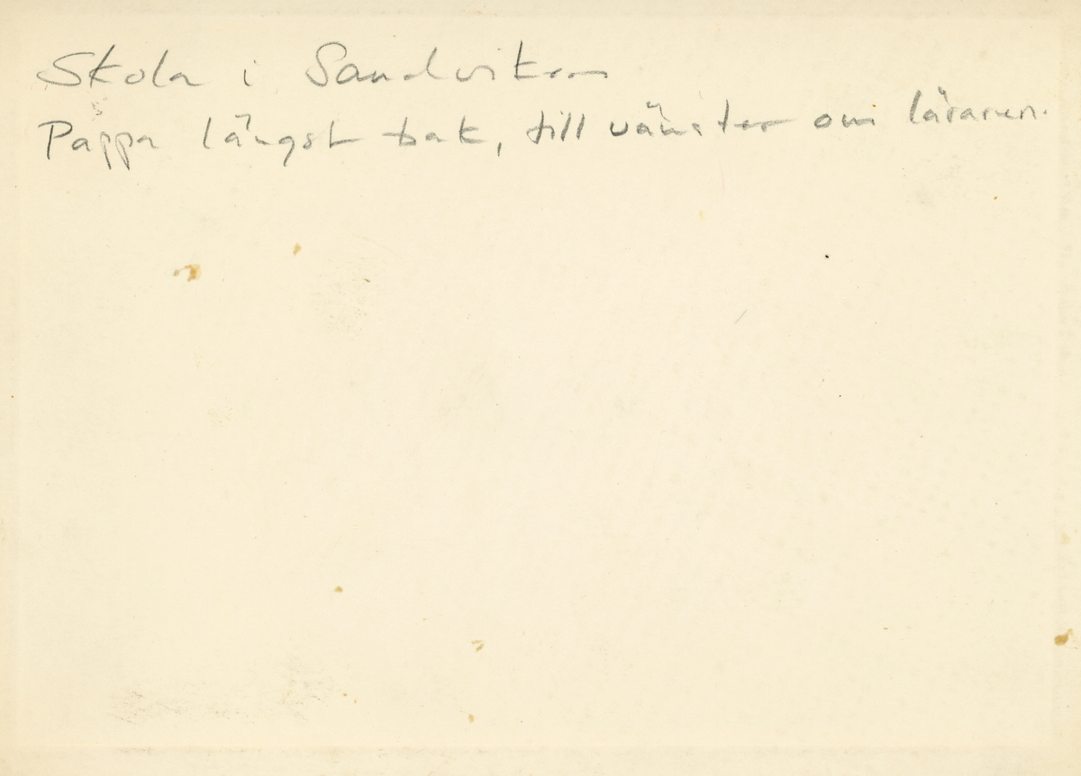 Foto av en skolklass i Sandviken. Text baksida kort: "Skola i Sandviken, pappa längst bak, till vänster om läraren".