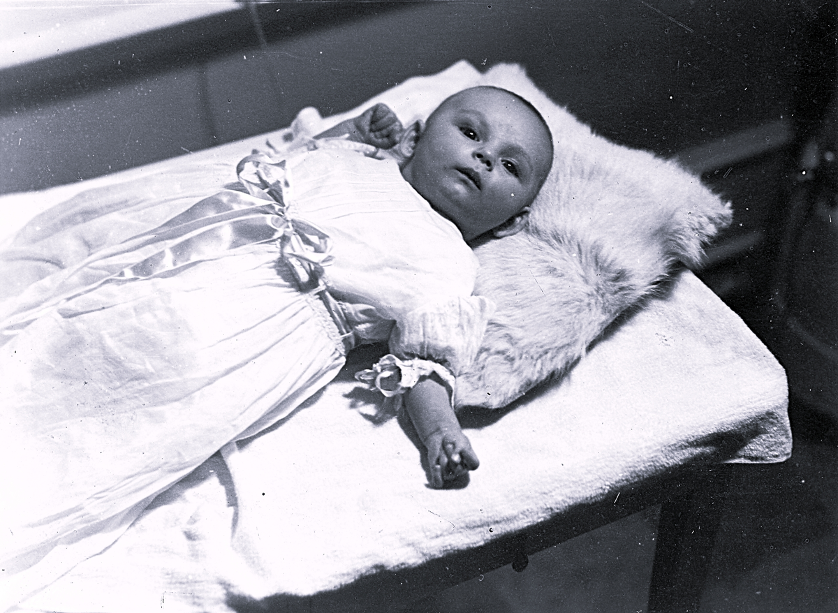 Foto av barn i dopklänning. Text baksida kort: "I dopstass".