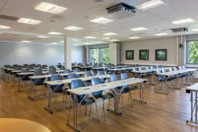 Et stort rom med mange oppstilte stoler og bord