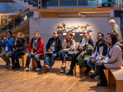 En gruppe voksne sitter i en halvsirkel og ser frem i samme retning