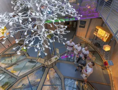 En gruppe håndballspillere ser opp på en tre-skulptur