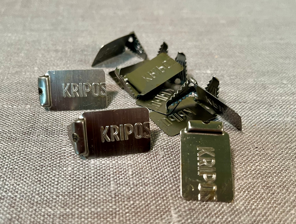 Et metallspann fullt av små ubrukte metallplomber.