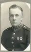 En ung man i uniform (m/95) med förtjänstmärken.
Bröstbild, halvprofil. Ateljéfoto.