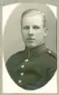 En ung man i uniform (m/95). 
Bröstbild, halvprofil. Ateljéfoto.