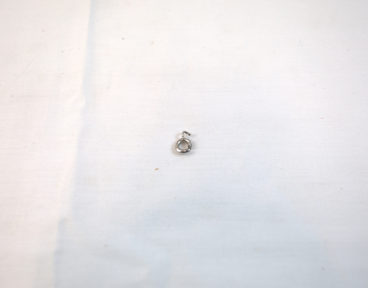 Liten ring i sølv, trolig del av kjede. 