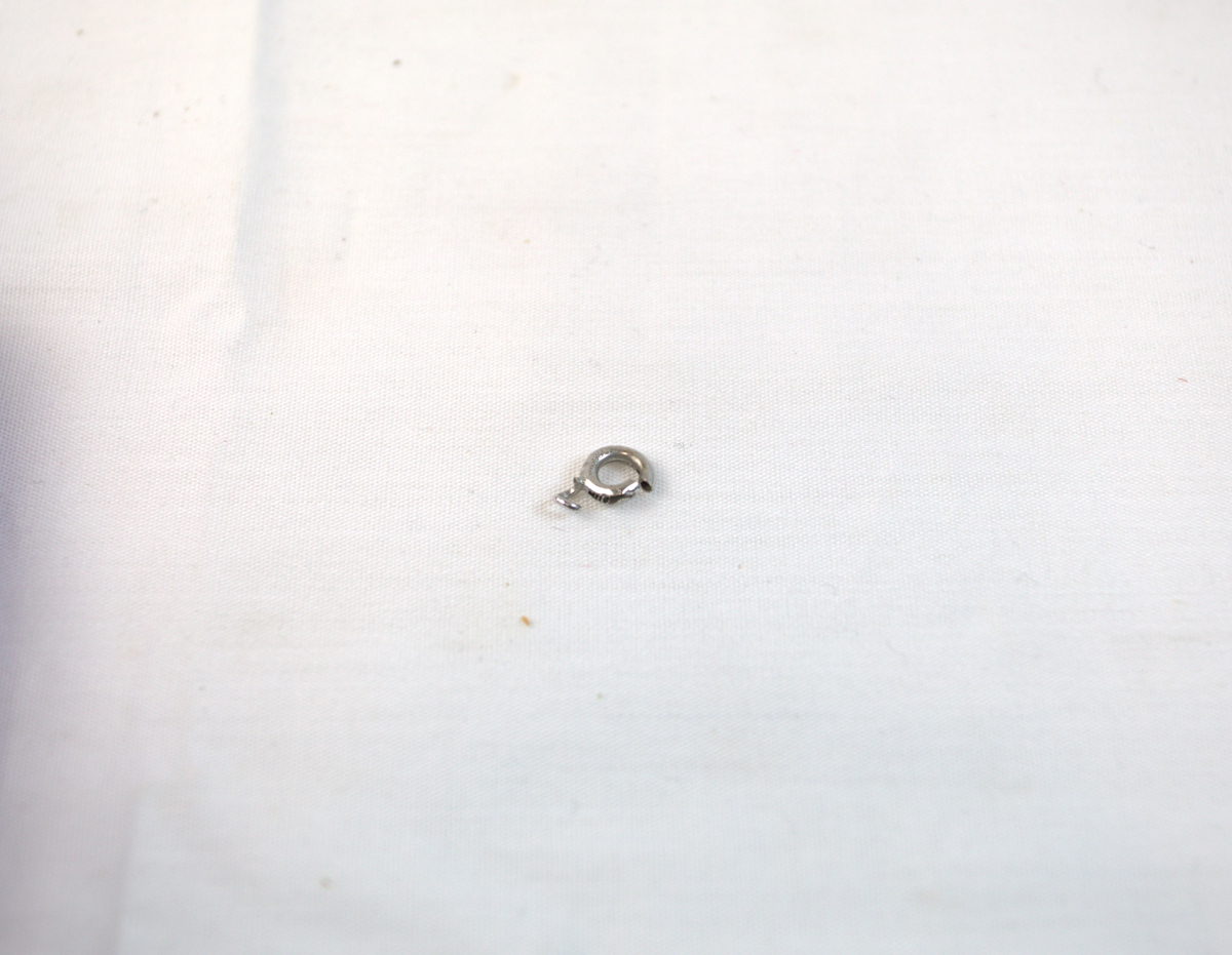 Liten ring i sølv, trolig del av kjede. 