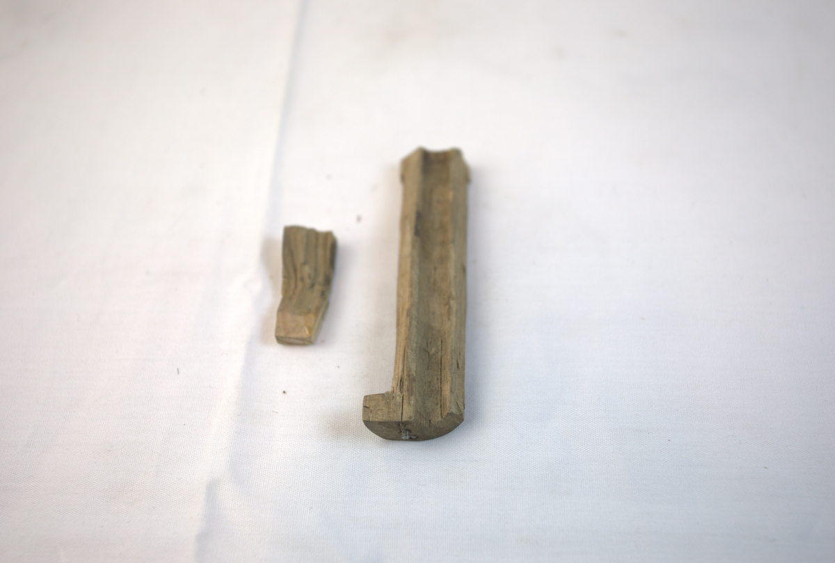 Biter av tre fra gullsmedvirksomhet. I den største biten er det spiker.