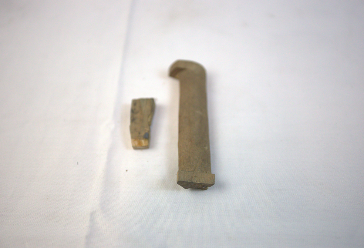 Biter av tre fra gullsmedvirksomhet. I den største biten er det spiker.