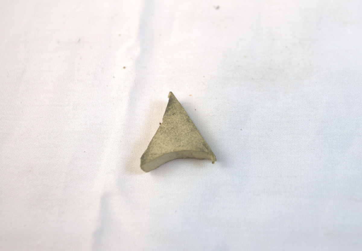 Trekantformet gjenstand i lett materiale.