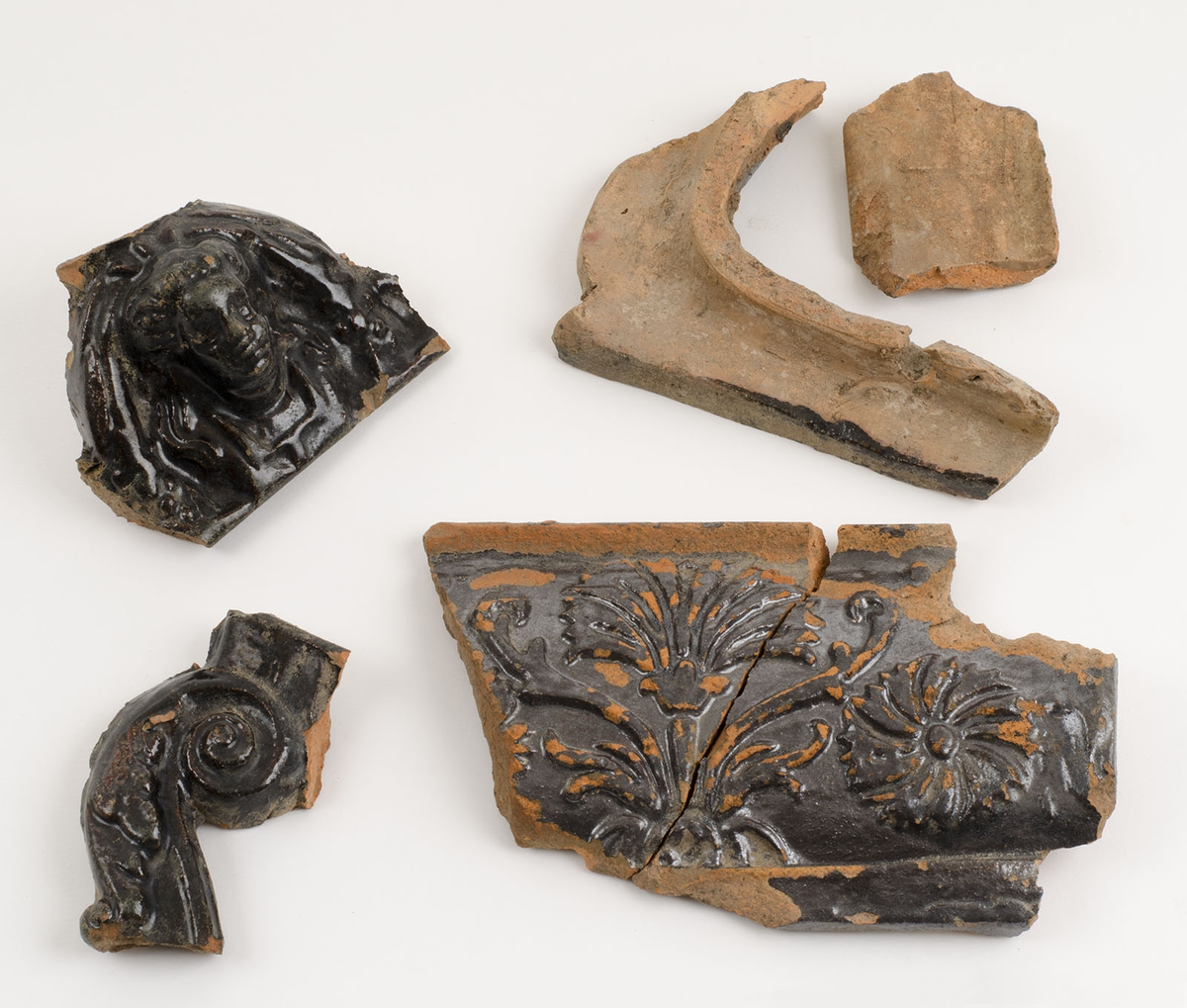 Reliefmönstrat med växtdekor samt människofigur, svartglaserat.