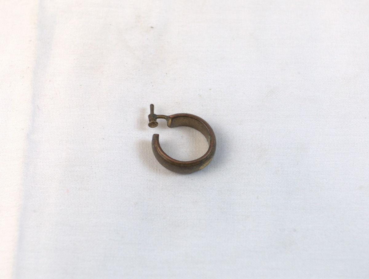 En ørering i gyllent metall.