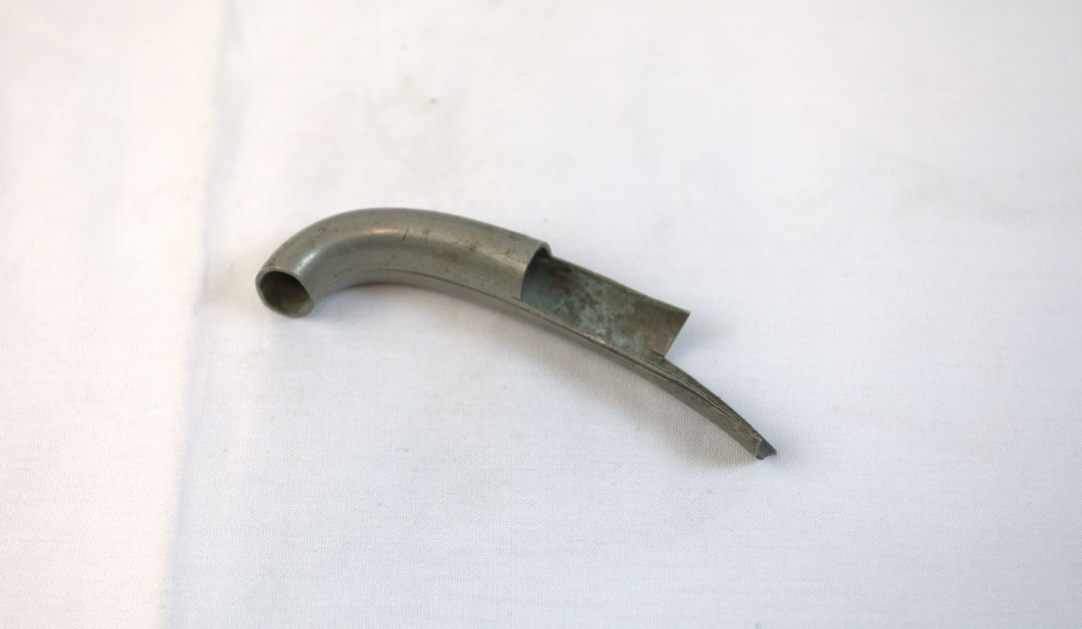 Metallrør som er buet og klippet med tre hakk i den ene enden.