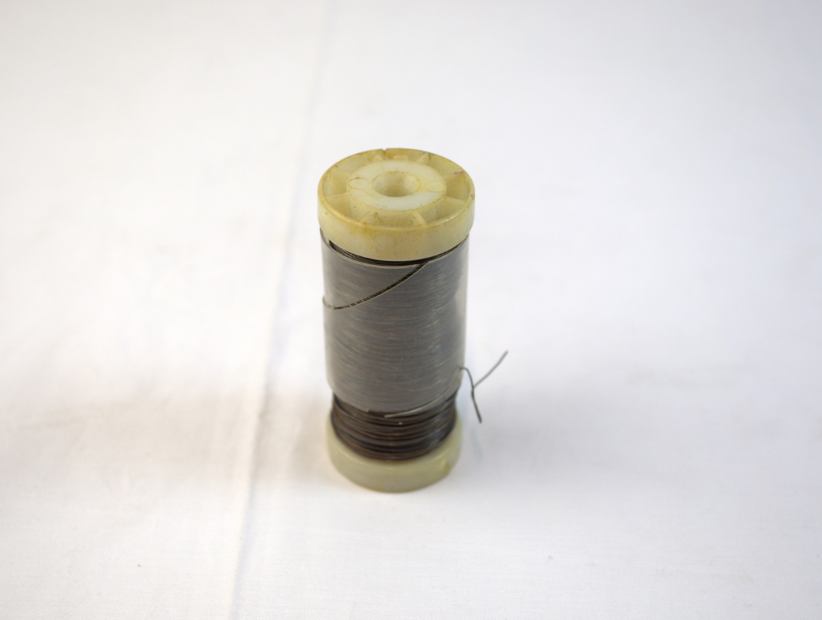 Ståltråd med bakelittsnelle. Det er også et gjennomsiktig plast/bakelitt-deksel rundt metalltråden.