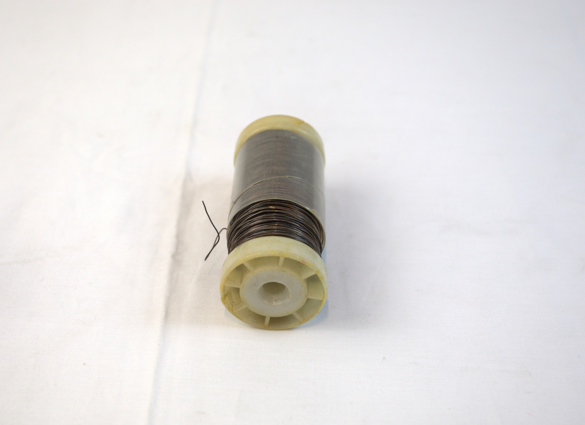 Ståltråd med bakelittsnelle. Det er også et gjennomsiktig plast/bakelitt-deksel rundt metalltråden.