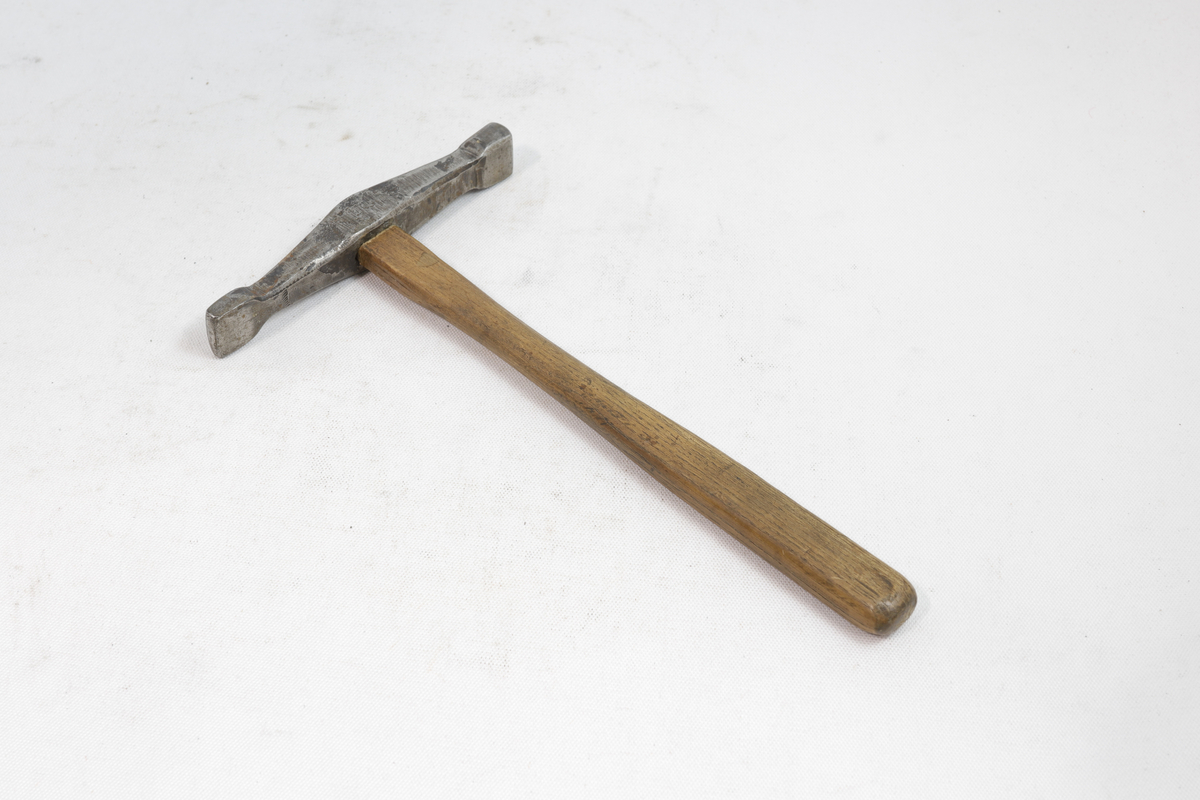 Hammer med skaft i tre og hammerhode i metall.