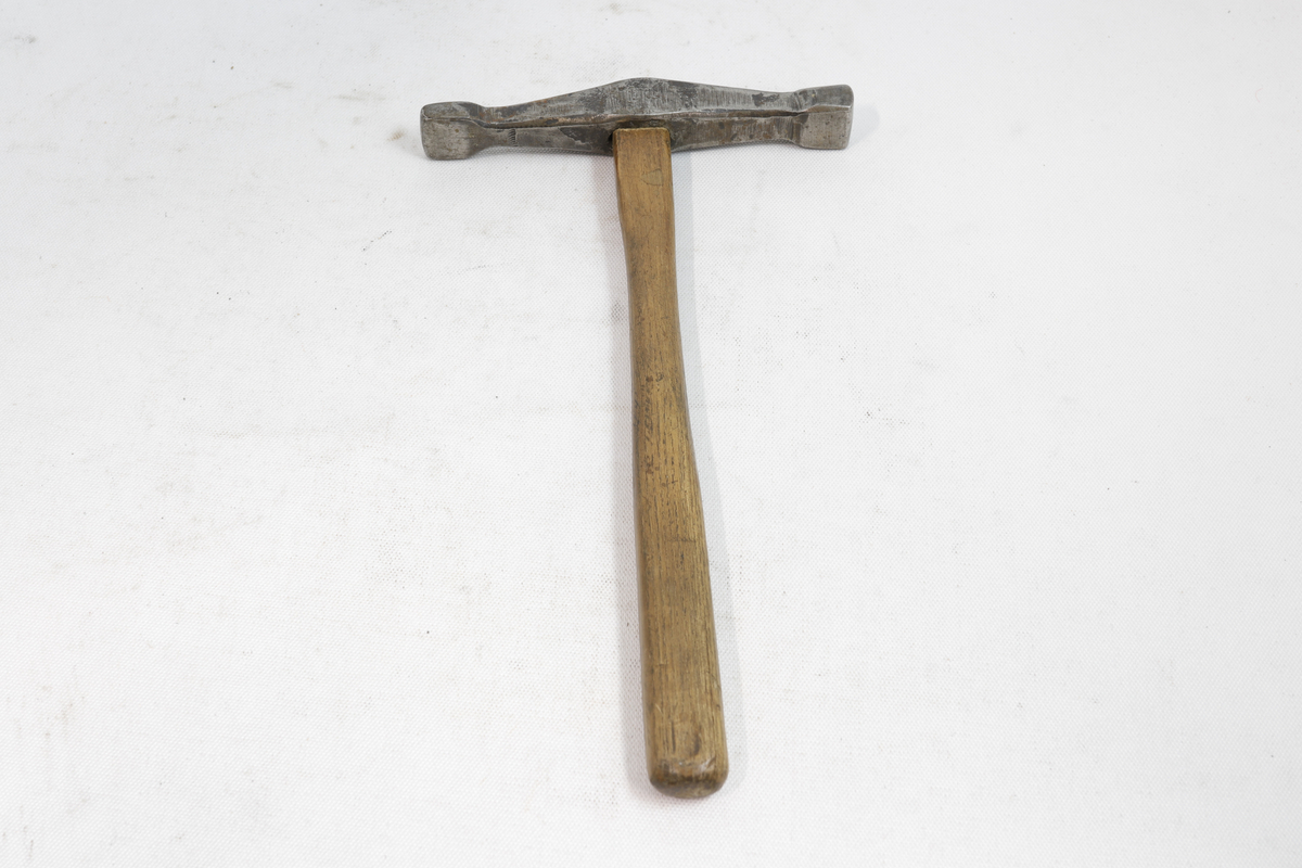 Hammer med skaft i tre og hammerhode i metall.