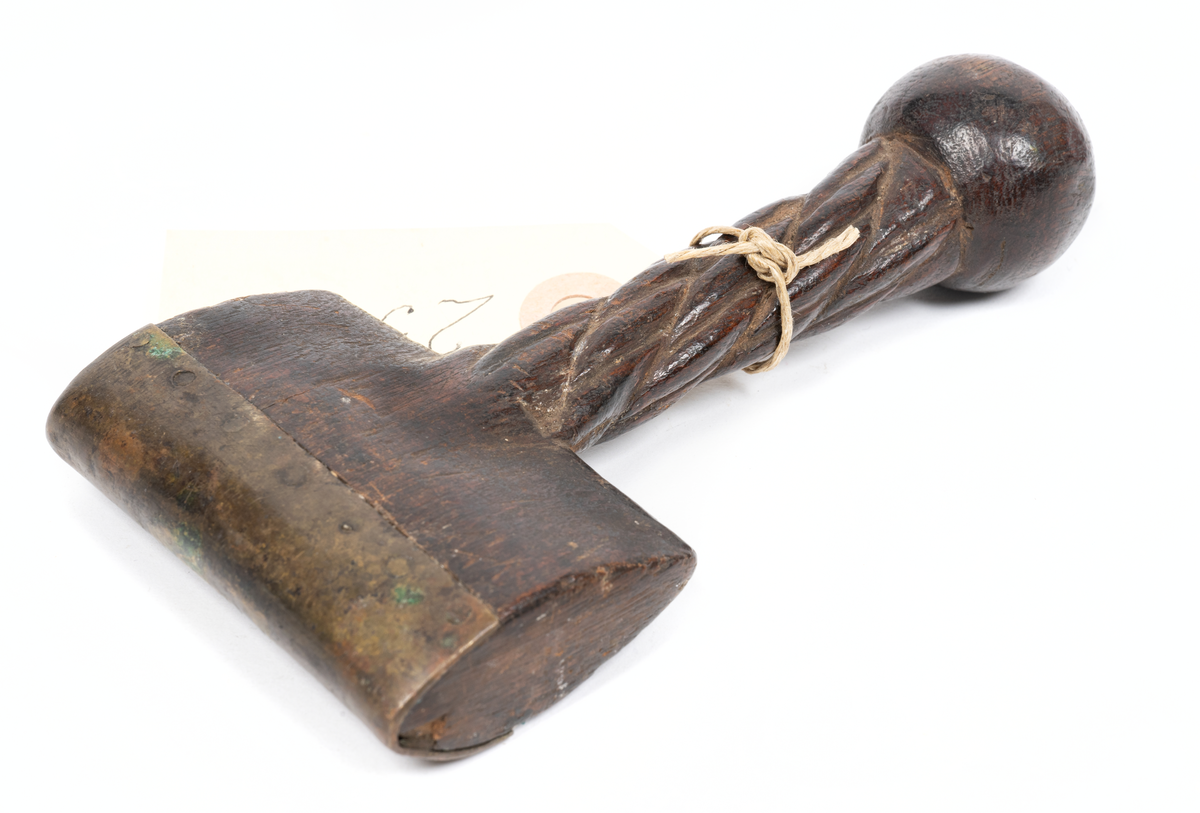 Sömstrykare med dekorerat skaft. Har använts för att styka ut beck med vid segelsömmeri.