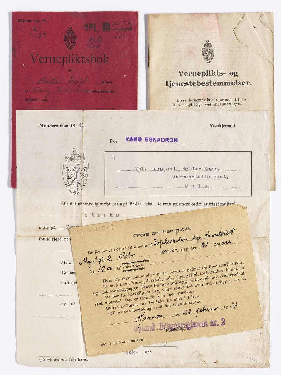 Rød heftet vernepliktsbok. I boken er det stukket inn et hefte om verneplikts- og tjenestebestemmelser, et militært tjenestebrevkort og et brev om mobilisering og oppmøte ved alminnelig mobilisering i 1940 .
