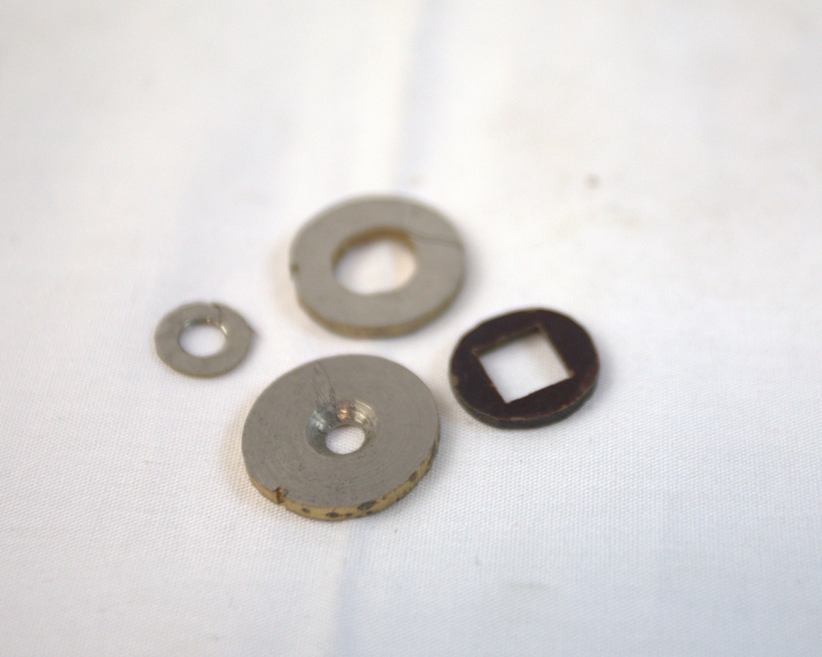 Runde gjenstander med hull i forskjellig metall.